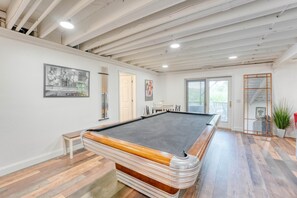 A pool table in a room with wooden flooring, white walls, and a ceiling with exposed beams. - Dockside Retreat on the Lake- Private Dock- Kayaks- Close to Bike Trails (Bella Vista)