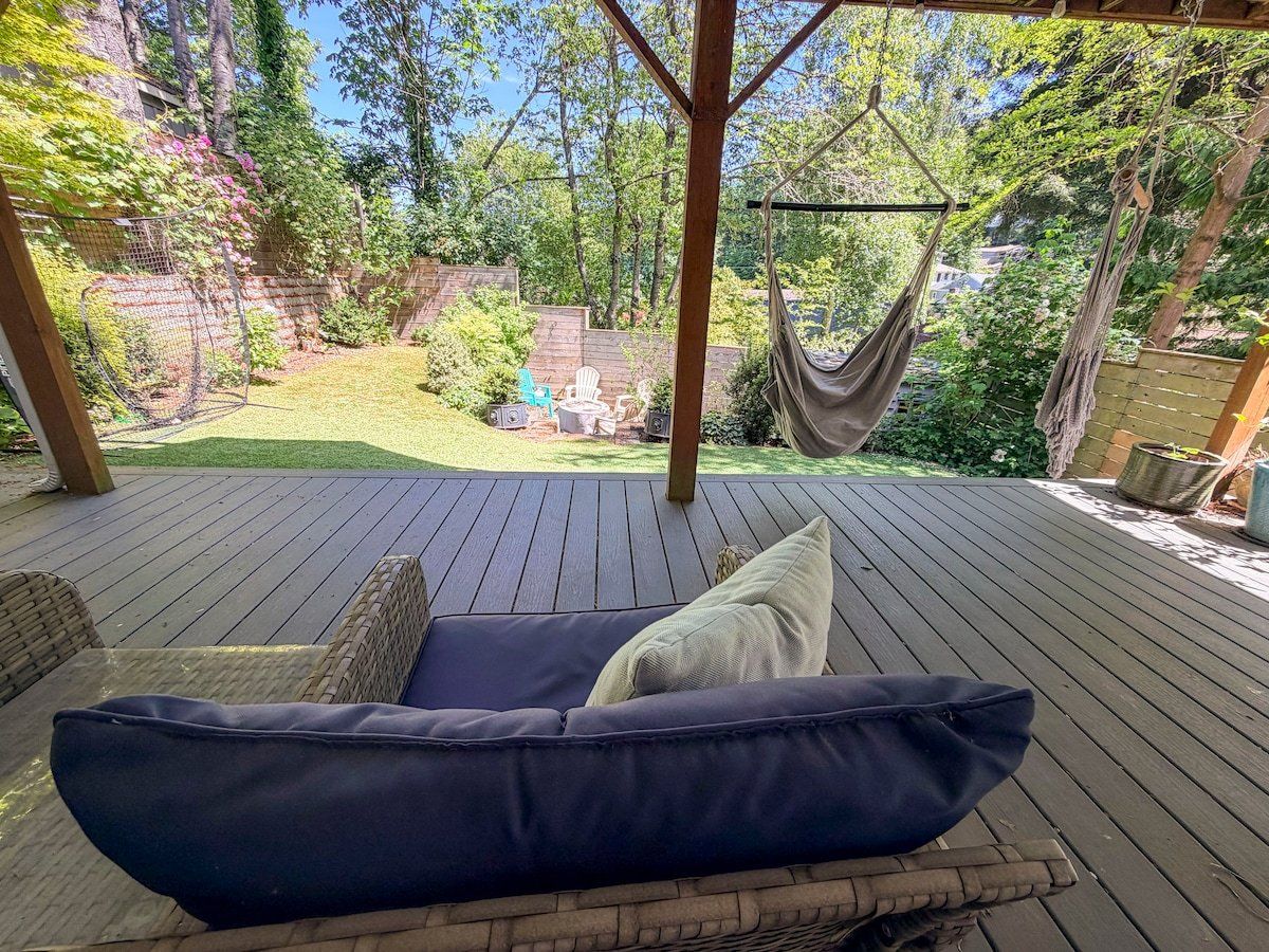A covered outdoor seating area with a cushioned bench and a hammock.