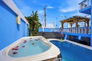 Una piscina con hidromasaje y una pérgola.