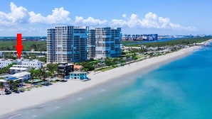 A coastal hotel with multiple high-rise buildings, a beachfront, and a clear blue sky. - Beautiful beachfront villa (Hollywood)