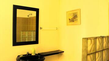 A bathroom with a black sink, a mirror, a towel rack, and a framed picture on the wall.