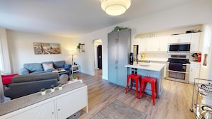 Een modern appartement met een zithoek, keuken en eetruimte.