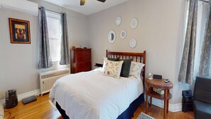 A bedroom with a bed, dresser, bedside table, and a radiator. - Your Home Away From Home. 3 Bedrooms and an office, walking distance to Gaslight (Cambridge)