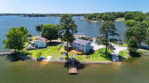 Una propiedad junto al lago con una casa grande, un muelle y varias embarcaciones.