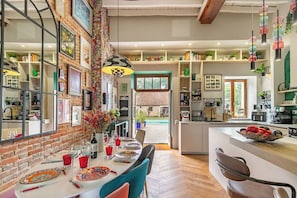 Uma cozinha ampla com área de refeições, paredes de tijolo e vista para o exterior.