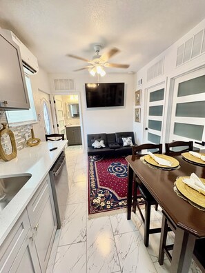 A modern kitchen with a dining area, a ceiling fan, and a TV mounted on the wall. - and welcoming.
Carrollwood Paradise
 2BR Apartment Central Tampa Near Everything (Tampa)
