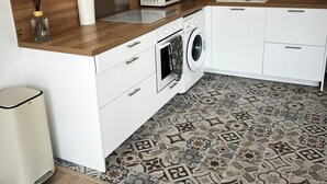 A modern kitchen with a microwave, washing machine, and sink. - Cosy apartment ideally located in the center of Corsica, close to hiking and beaches. (PIEDIGRIGGIO)