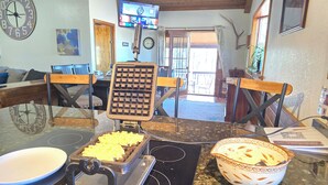 A kitchen with a waffle maker, a bowl, and a plate on the counter. - Munds Park Basecamp Cabin (Sedona)