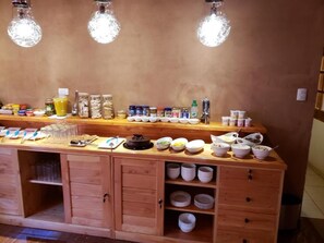 Um balcão de buffet de madeira com diversos alimentos e acompanhamentos.