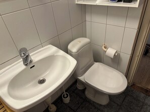 Un baño con lavamanos, inodoro y bidé.