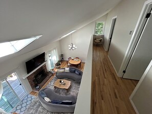 Amplia sala de estar con chimenea, televisor y mesa de comedor.