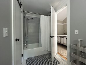 Un baño con bañera, ducha e inodoro.