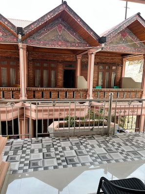 Ein Gebäude mit einem Balkon, gefliestem Boden und einem Metallgeländer.
