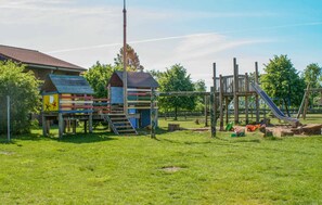 Ein Spielplatz mit Rutsche, Klettergerüsten und einem umzäunten Bereich.