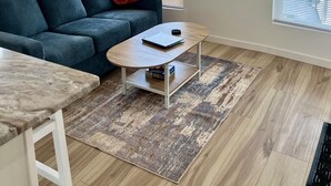 Una sala de estar con sofá, mesa de centro y ventilador de techo.