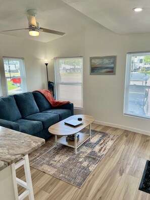 A living room with a sofa, coffee table, and a ceiling fan. - GOTL- Sun Retreats/Heated Pool/Free Golf Cart (Geneva)