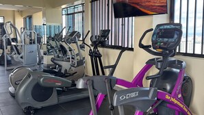 Et fitnesscenter med motionscykler, løbebånd og et tv, der viser en motiverende besked.