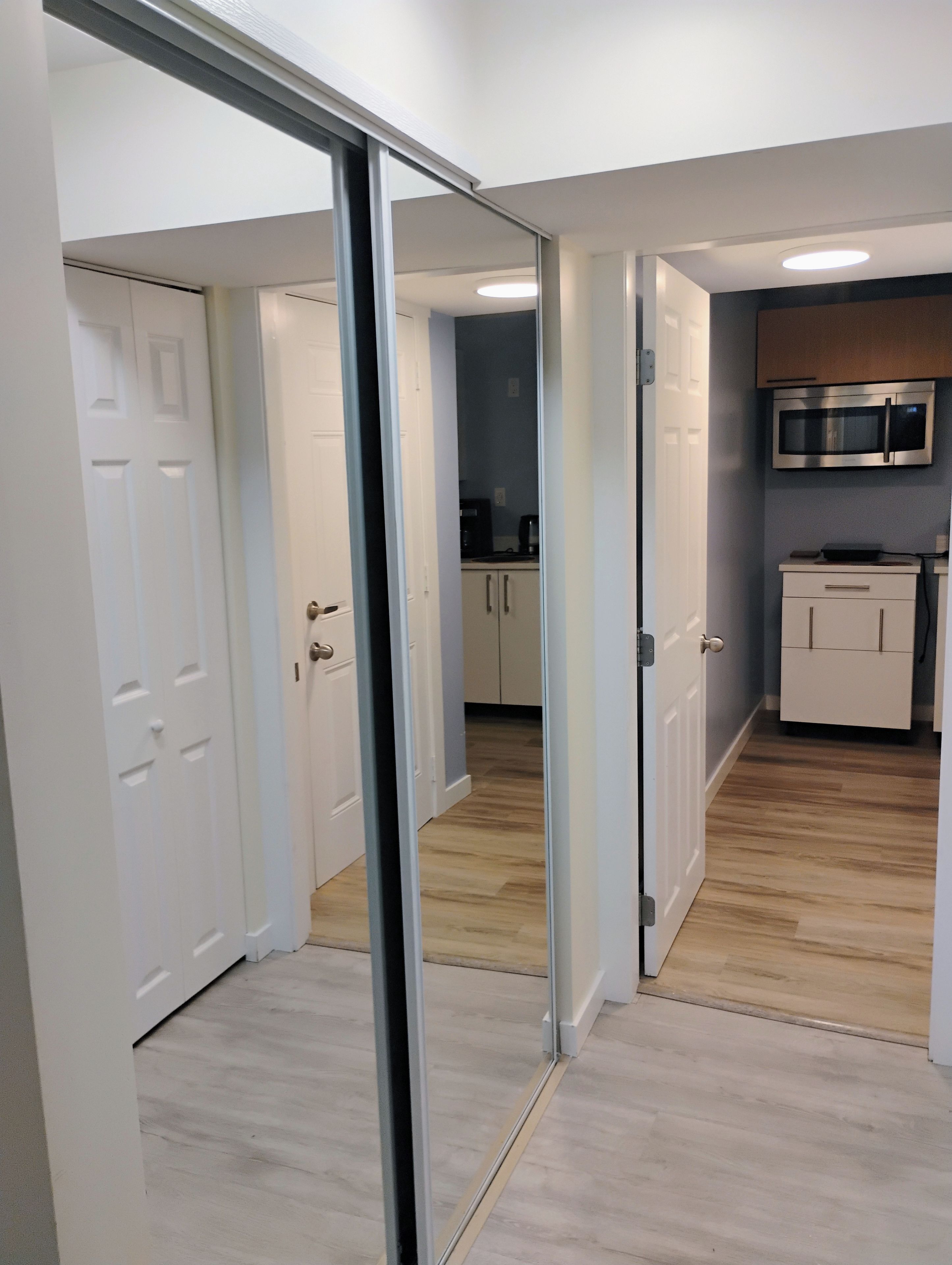 A modern kitchen with a microwave, cabinets, and a coffee maker.