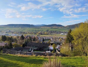 A residential area with houses, a fence, and a view of distant hills. - Cozy 2 Bedrooms, Mountain View Private suite (Vernon)