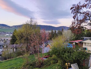 A residential area with houses, trees, and a distant view of a town. - Cozy 2 Bedrooms, Mountain View Private suite (Vernon)