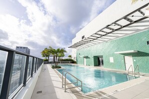Ein Dachpool mit Glasgeländer, einer Kachelwand und einer Tür zu Umkleideräumen.