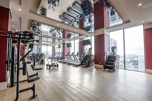 A gym with treadmills, weight machines, and a view of the city. - The Crosby #308 Elegant Urban Studio (Miami)