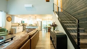 Un salon moderne avec un canapé, une table à manger et un escalier.
