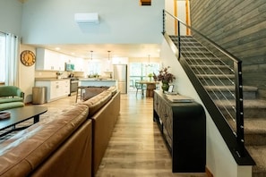 Una sala de estar moderna con un sofá, una mesa de comedor y una escalera.