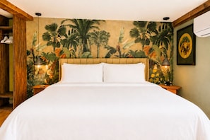A bed with a headboard, a wall mural of tropical plants, and two bedside lamps. - Catskill Creek w/ Deck & Views (Jefferson Heights)