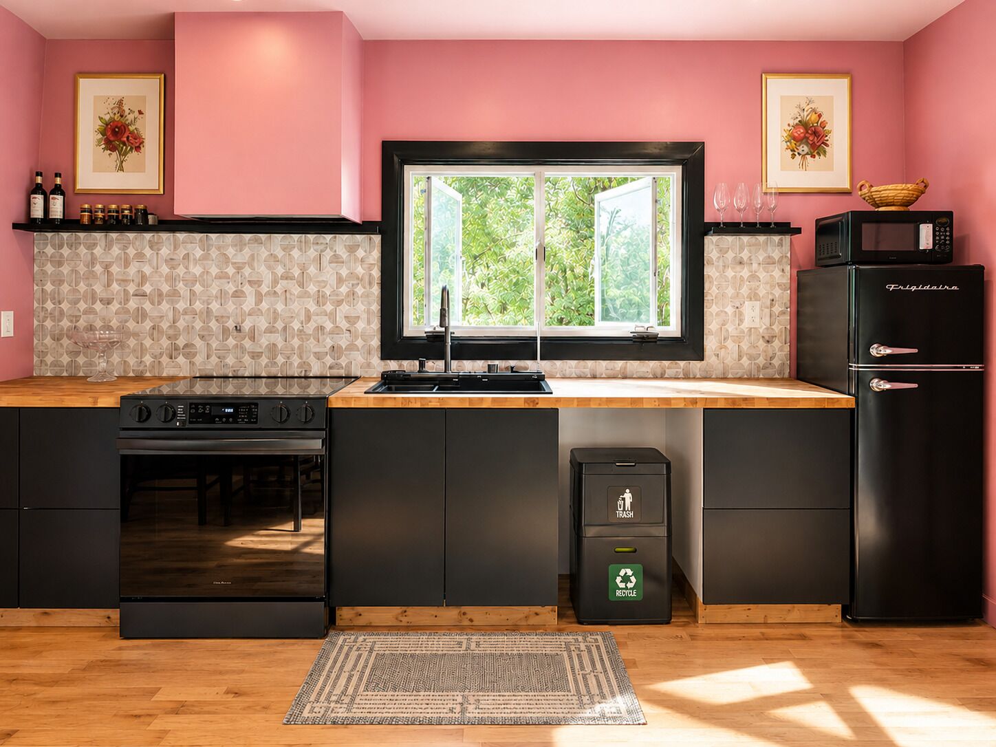 A modern kitchen with a black refrigerator, a stove, and a trash bin.