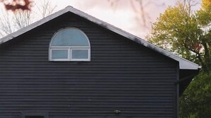 A dark wooden building with a yellow door, a small window, and a number '3' on the wall. - Catskills Getaway Nature Views Fire Pit (Jefferson Heights)