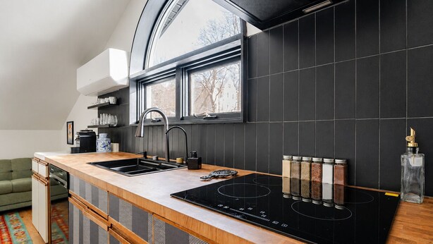 A modern kitchen with a black backsplash, a window above the sink, and a built-in stove. - Catskills Getaway Nature Views Fire Pit (Jefferson Heights)