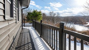 A wooden deck with a railing overlooking a river and trees. - Catskills Getaway Nature Views Fire Pit (Jefferson Heights)