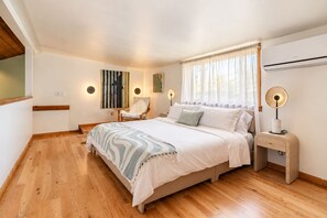 A bedroom with a bed, bedside table, chair, artwork, and a window with curtains. - Creekview Catskill Lodge & Mountain Views (Jefferson Heights)