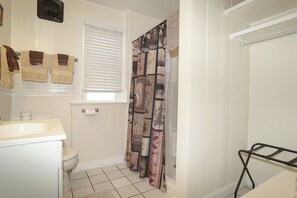 A bathroom with a toilet, sink, and shower curtain.