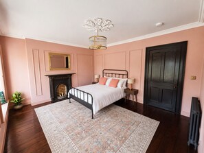 A bedroom with a bed, a fireplace, a door, and a radiator. - No.60 Sligo (Sligo)