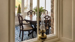 Un coin repas comprenant une table et des chaises, une plante en pot et une lampe décorative.