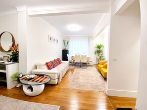 Ein modernes Wohnzimmer mit Sofa, Couchtisch, Esstisch und Stühlen.