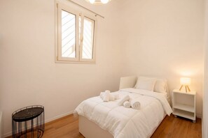 A bedroom with a bed, a bedside table, a lamp, a window, and a small round table. - Maison Manzoni - Contemporary Elegance (Bari)