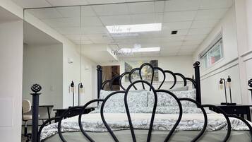 Una cama con estructura metálica original, un techo con tragaluces y vista del interior de la habitación.