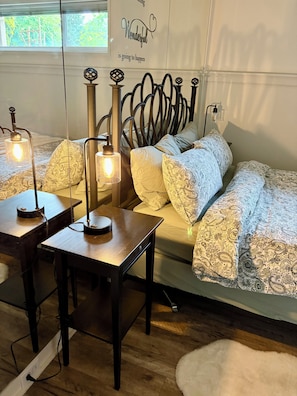 A bedroom with a bed, bedside tables, and a wall with a poster.