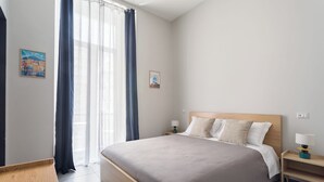 A modern hotel room with a large bed, bedside tables, and a window with curtains. - Darna Rooms (Naples)
