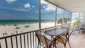 Ein Balkon mit Blick auf Strand und Meer.