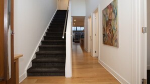 A staircase with a handrail, wooden flooring, and a painting on the wall. - Margaret House | Elegant City-Fringe Escape (North Adelaide)