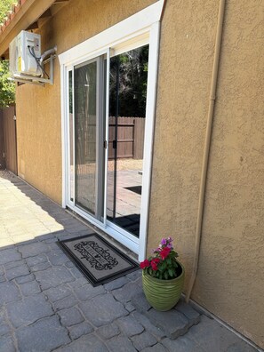 Ein Haus mit Schiebetür, einem Blumentopf und einer Fußmatte.