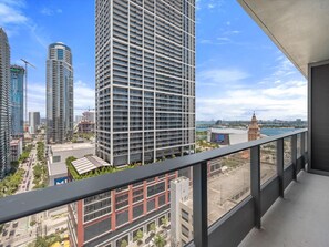 Ein Hochhaus mit modernem Design, ein Balkon mit Metallgeländer und Blick auf die Stadtlandschaft.