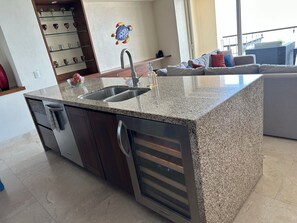 A kitchen with a granite countertop, stainless steel sink, and a built-in oven. - Amazing ocean view 1 Bedroom condo in Conchas Chinas. (Puerto Vallarta)