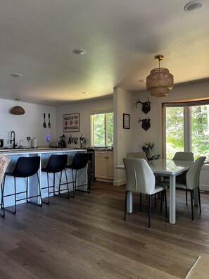 A modern kitchen with a bar area, dining chairs, and a table. - 4-bedroom Leech Lake Retreat on Quiet Agency Bay (Walker)