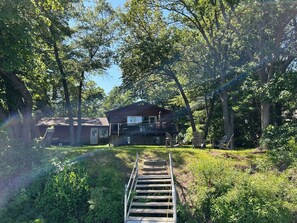 A wooden house with a balcony, surrounded by trees and a grassy area. - 4-bedroom Leech Lake Retreat on Quiet Agency Bay (Walker)