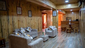 Un interior de madera con sofás, una mesa de centro y una zona de comedor.